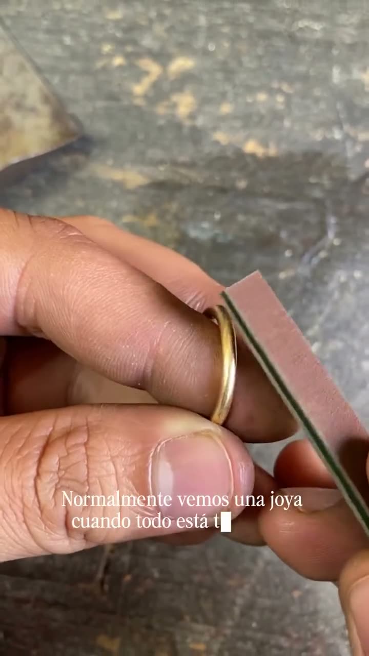 Manos del joyero puliendo un anillo de oro en el banco de trabajo